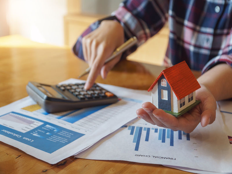 Calcul du budget des travaux, maquette de maison à la main