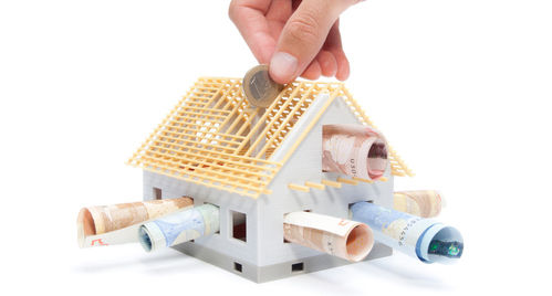 Pièce glissée dans une maquette de maison en construction