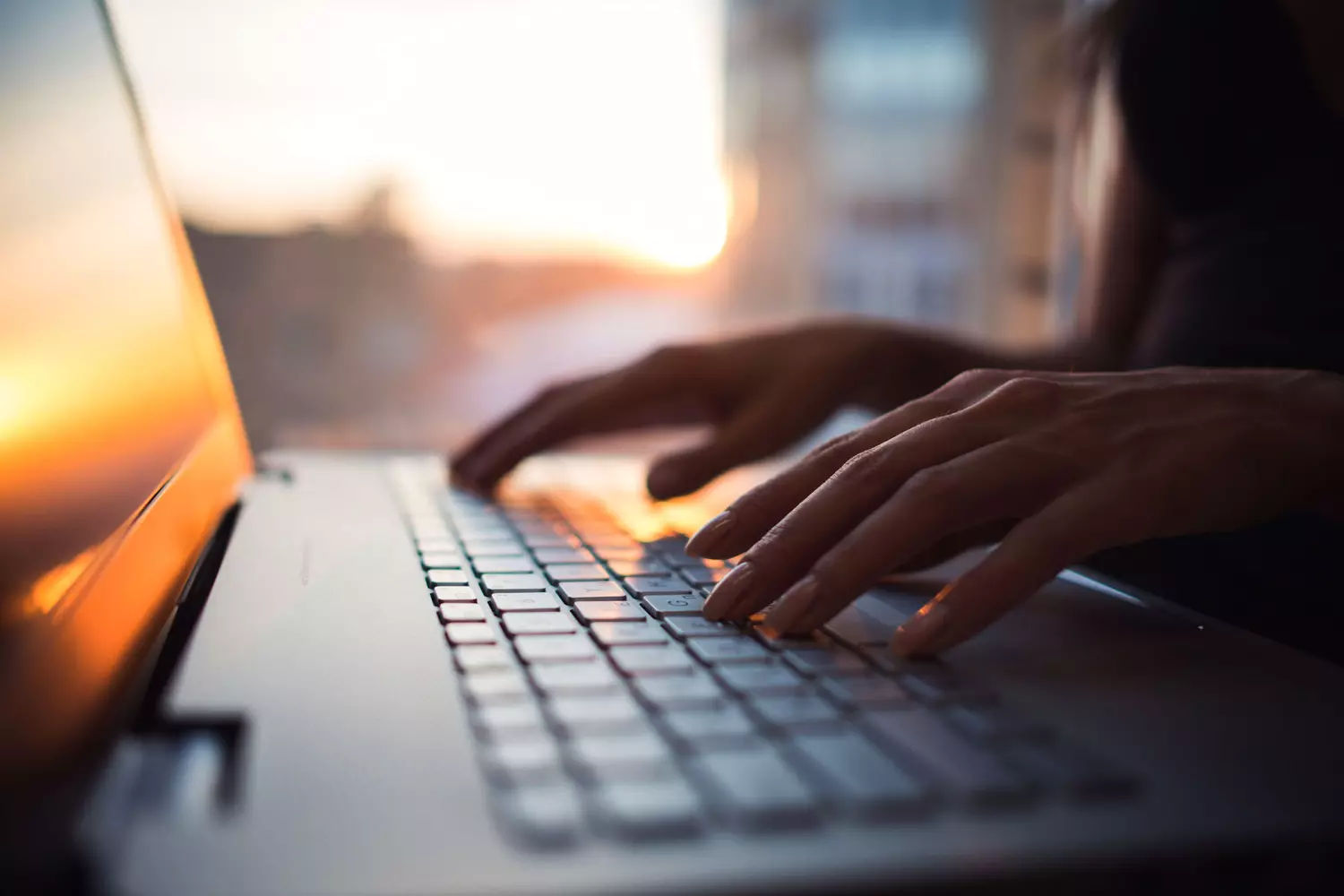 Mains tapant sur le clavier d’un ordinateur portable