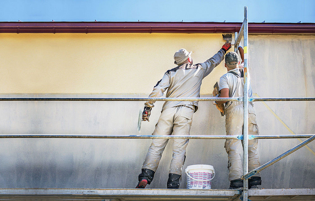 Façadiers peignant un mur extérieur depuis un échafaudage